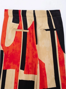 Detailed back view of patterned trousers with red and black abstract color block design
