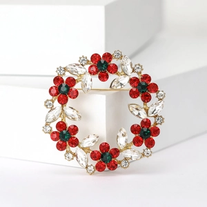 Elegant gold wreath brooch featuring red rhinestone flowers and clear crystal leaves