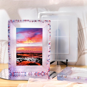 Detail of DIY picture frame silicone mold with beaded resin craft on wooden background