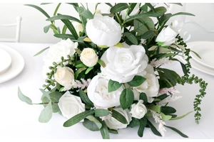 Detail showing white silk roses and peonies with cascading green vines for wedding decor