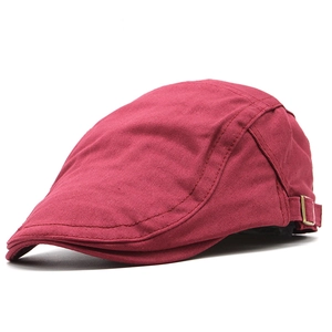 Close-up of wine red cotton flat cap with bronze metal buckle and twill texture