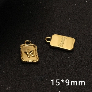 Macro detail of golden butterfly charm with Beauty engraving and 15x9mm dimensions