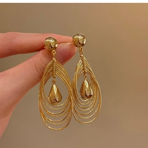 Detailed macro view of 18k gold-plated multi-layer teardrop hollow earring with polished finish