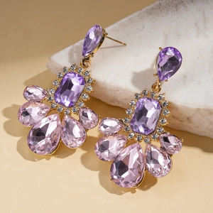 Detail of vintage gold earrings with purple crystal pendants and sparkling rhinestones