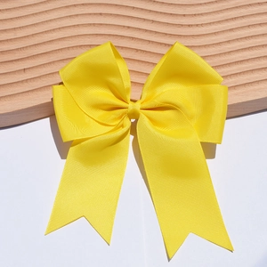 Close-up of a 6-inch yellow ribbed grosgrain ribbon bow hairclip with double streamers