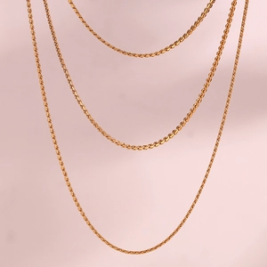 Detailed view of three 18K gold plated stainless steel snake chains in various textures