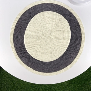 Close-up of circular woven placemat with two-tone beige and grey spiral texture