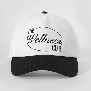 Detailed view of Wellness Club embroidery on a black and white two-tone baseball cap