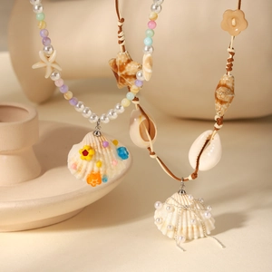 Detail of bohemian necklaces featuring natural shell pendants and colorful beaded chains