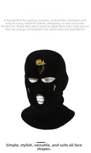 Detail of embroidered gold rose on black knitted 3-hole balaclava ski mask