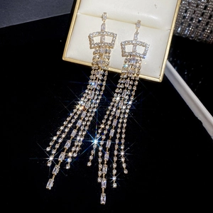 Close-up of elegant crown earrings with long cubic zirconia tassels and gold plating