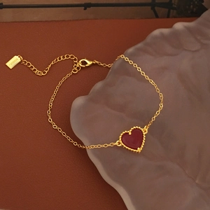 Detail of red heart pendant with gold beaded edges on a delicate chain necklace