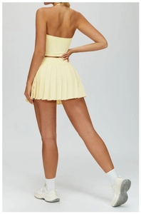 Detail of light yellow pleated tennis skirt with high-stretch fabric and back view design