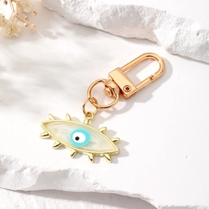 Detailed close-up of golden metal Evil Eye keychain with blue enamel eye charm