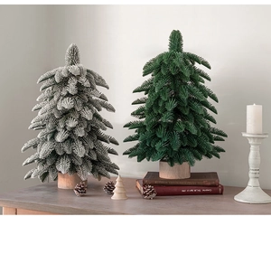 Mini PE artificial Christmas trees with snow effect and wooden base on a festive table