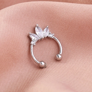 Macro shot of silver non-pierced nose ring with marquise gems on pink silk