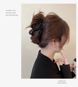 Detail showing a 13cm matte black wave hair claw clip styled on a woman's hair