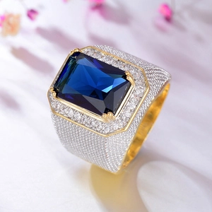 Macro di un anello da uomo con grande pietra blu rettangolare e diamanti incastonati