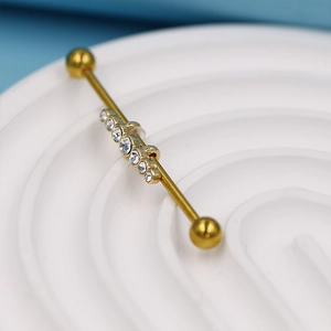 Vue macro détaillée du piercing industriel doré orné de sept pierres de zircon blanc