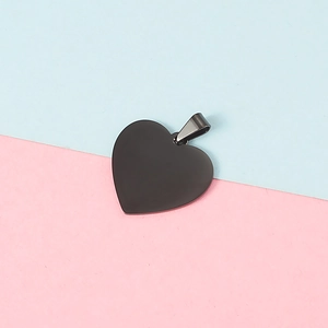 Detail of 25mm black heart-shaped pendant with metal ring on two-tone background