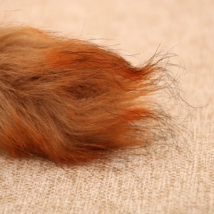 Macro shot of faux fur texture on squirrel ornament over rustic burlap backdrop