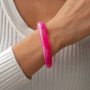 Close-up of pink marble acrylic resin bangle on model wearing a white ribbed sweater