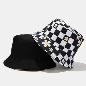 Women's reversible bucket hat featuring black fabric and daisy checkered patterns