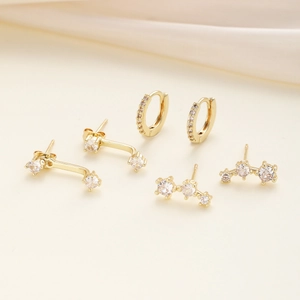 Detailed set of three golden stud earrings and hoops featuring brilliant zircon stones