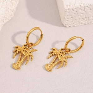 Detail shot of 18K gold plated stainless steel palm tree earrings on white stone