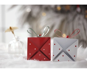 Close-up of festive envelope gift boxes with polka dots and ribbons on plush carpet