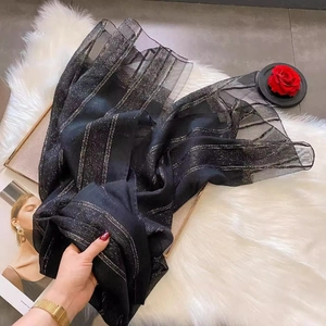 Detail of black silk wool scarf featuring elegant silver stripes on a textured mesh fabric