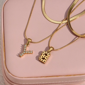 Close-up of 18K gold double layer chain with zircon Y letter and heart pendant charms