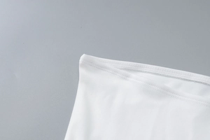 Close-up of double-needle stitching and white knitted fabric on a strapless dress