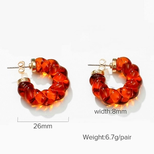 Detail showing amber resin twisted C-shaped earrings with 26mm diameter and 8mm width