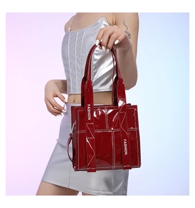Detail der dunkelroten Lackleder-Umhängetasche mit weißen Nähten und Modegurt-Design