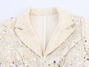 Détail du col en tweed à paillettes sur une robe blazer élégante pour femme blanc cassé
