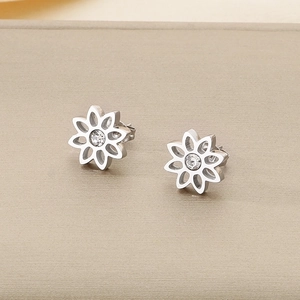 Vue macro de boucles d'oreilles lotus en acier inoxydable avec zircons clairs