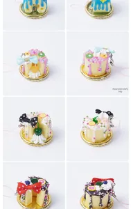 Detail of assorted mini fake cream cake keychains with colorful fruit toppings and gold trays
