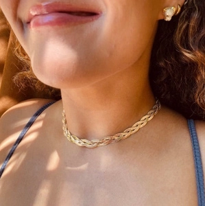Dreilagige goldene geflochtene Flachpanzerkette für Damen am Model mit sanftem Schattenwurf