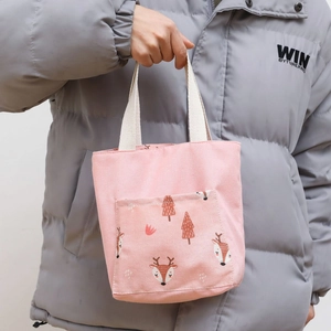 Detailed view of pink canvas tote bag with cartoon deer print and thick woven handles