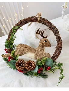 Detail of Christmas wreath with natural twigs, straw reindeer, pine cones and red berries