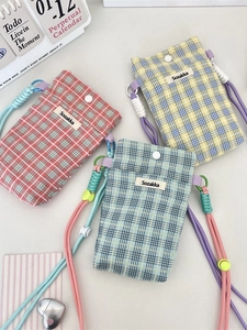 Three colorful checkered crossbody phone bags with woven straps and button closure