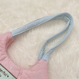 Detalle de bolso tote acolchado rosa y azul con tirantes y costuras reforzadas