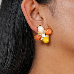 Vue détaillée des boucles d'oreilles fleurs en résine avec pétales colorés et perle