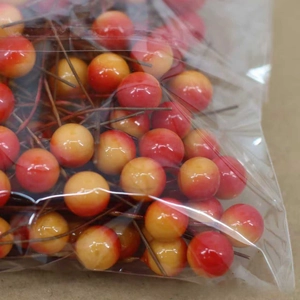 Macro detail of red and yellow gradient artificial berries for DIY Christmas wreaths