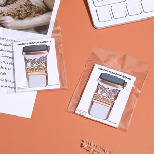 Detail of rose gold butterfly watch band charms with purple rhinestones and packaging