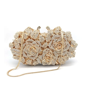 Macro shot of gold rose evening clutch with crystal rhinestones and metal chain
