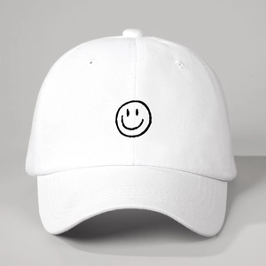 Detailed view of minimalist white cotton baseball cap with black embroidered smile pattern