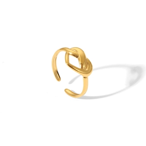 Vue détaillée d'une bague ouverte en forme de nœud doré poli avec un anneau réglable sur blanc