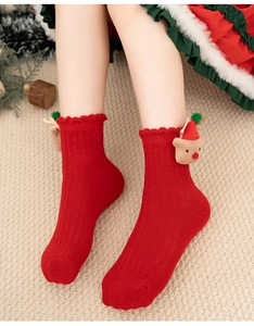 Close-up of red Christmas socks with cute 3D bear figurines and wavy knit cuff detail